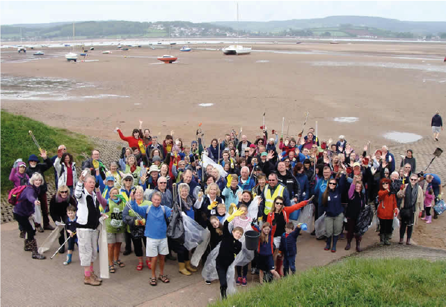 a group of people helping clean the beach