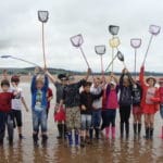 a group of children holding fishing nets in the air