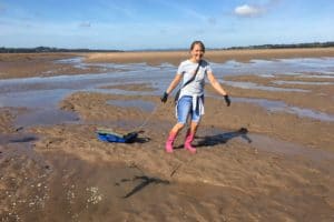 Woman pulling sled along sand