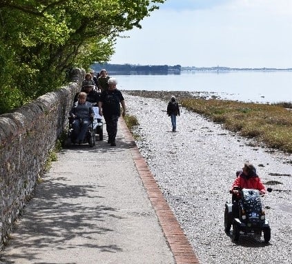 People on a path by the sea.