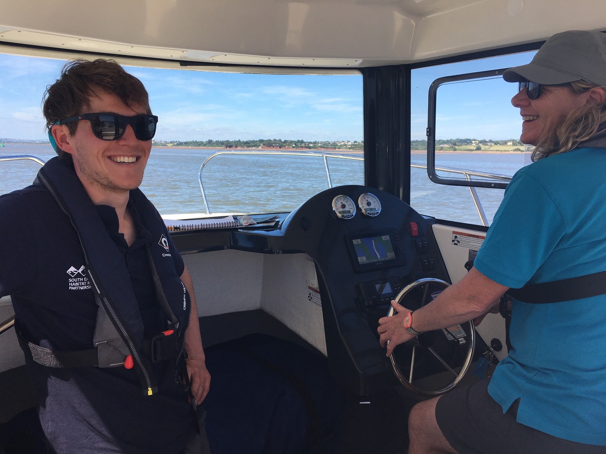 A photograph of two people on a boat.