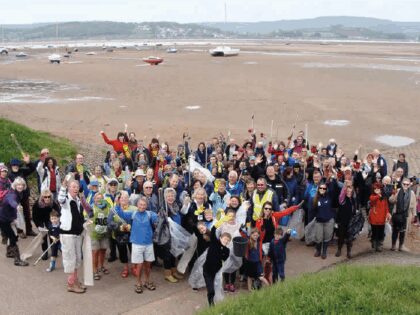 a group of people helping clean the beach