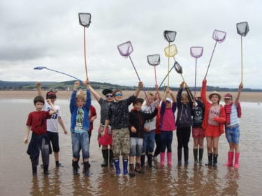 a group of children holding fishing nets in the air
